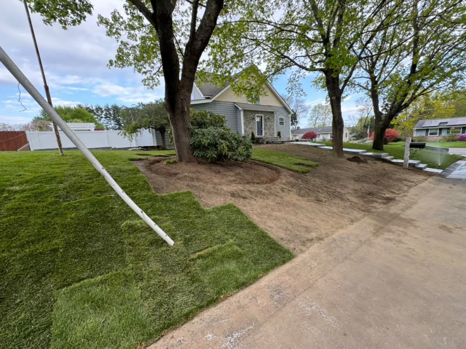 Fresh sod lawn and grading around a Massachusetts home with new granite curbing